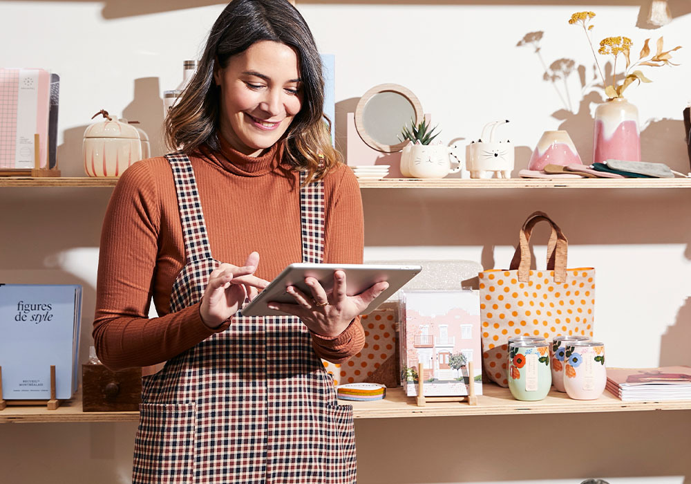 Smiling woman holding a tablet in her retail store.